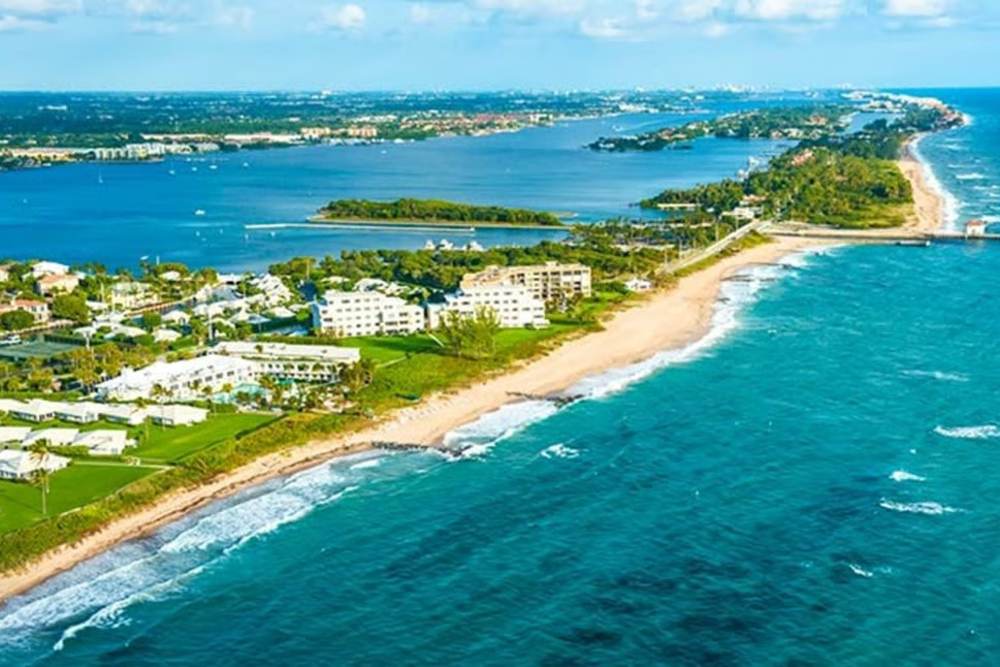 Boynton Beach Florida - Dixon Law Firm Aerial view of a coastal resort town with white buildings along a sandy beach and turquoise sea
